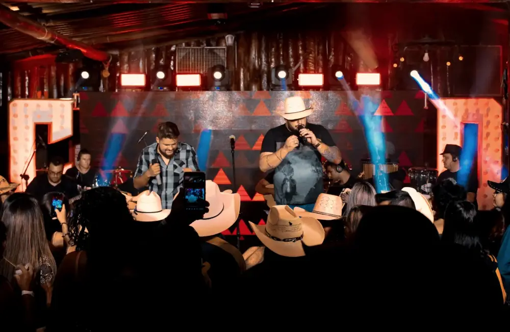 Cadu & Diego em palco lotado com chapéus na plateia